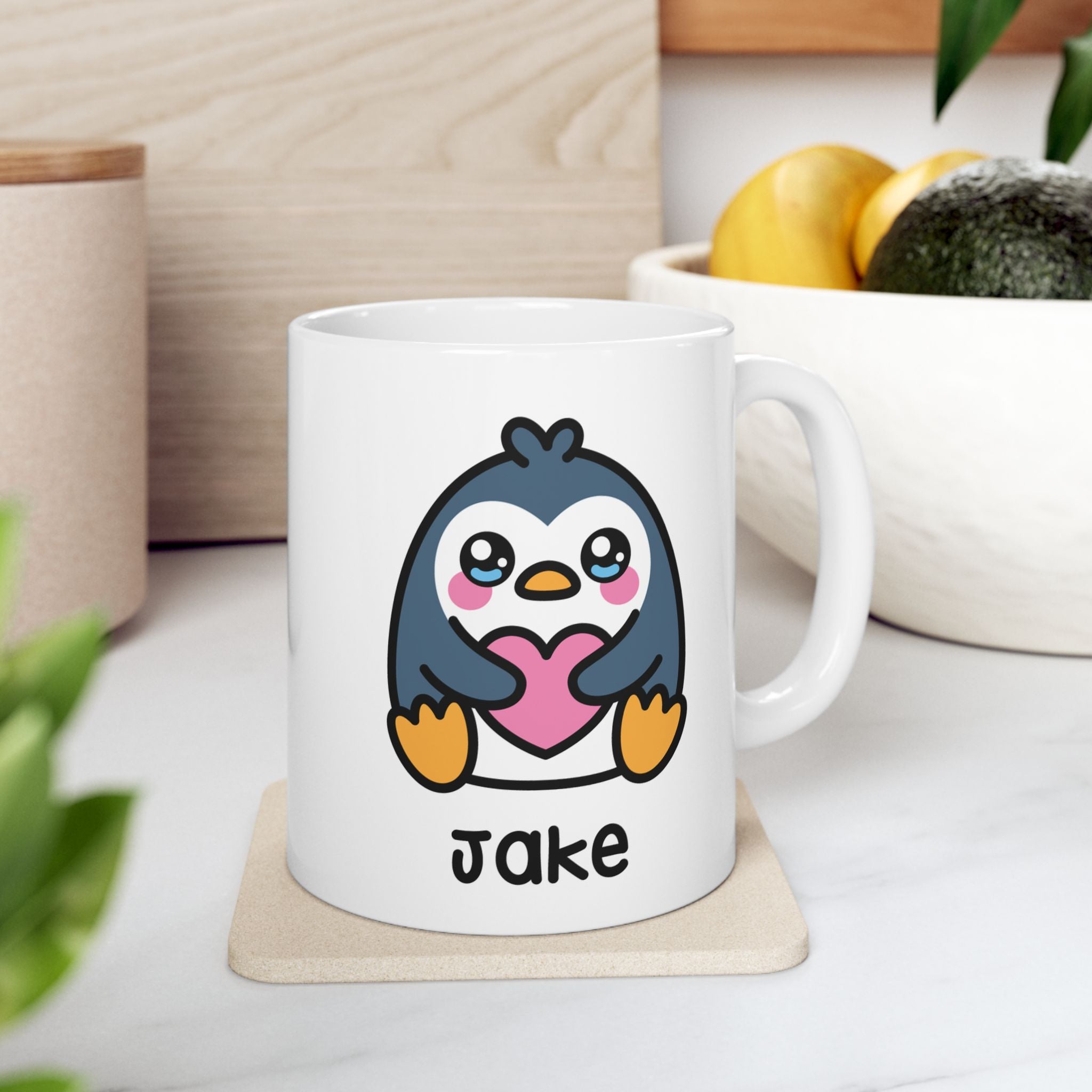 White mug with a cartoon penguin holding a heart on a wooden surface.