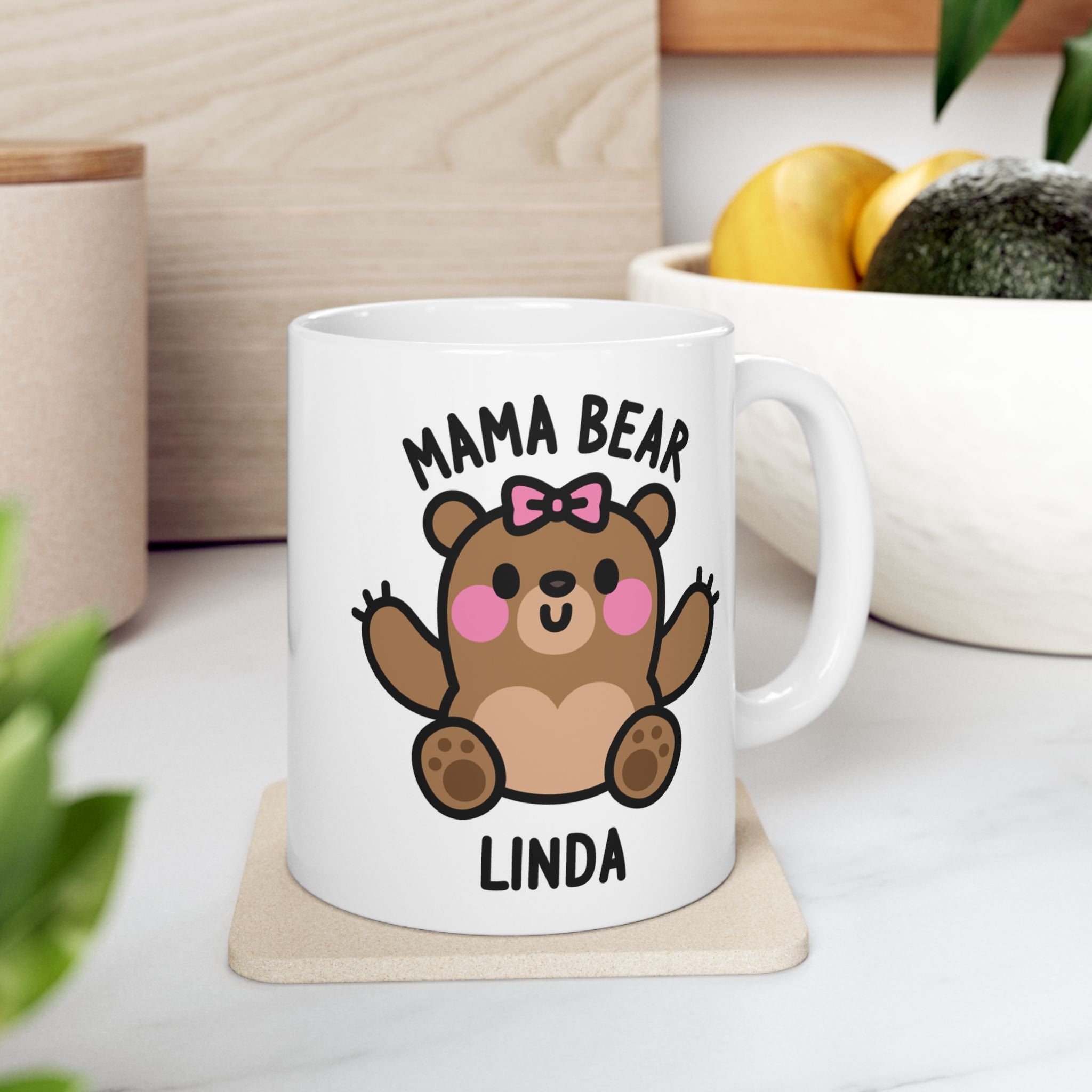 White mug with a cartoon bear design and 'Mama Bear' text on a wooden surface.